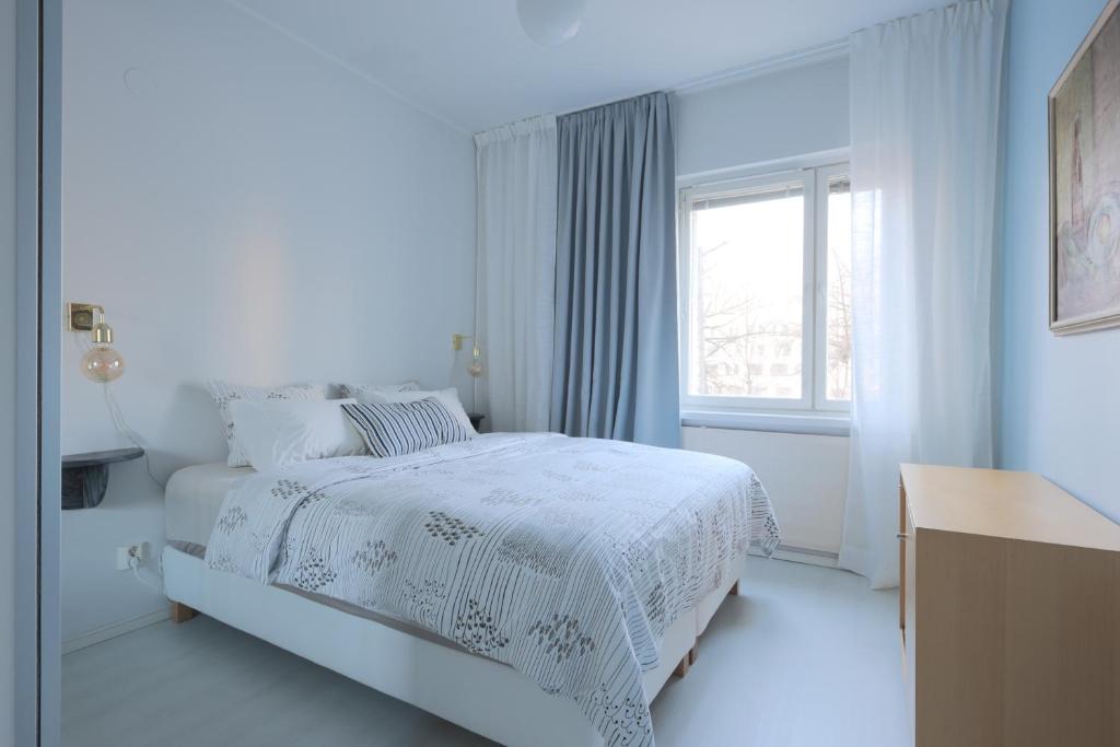 赫尔辛基Urban Oasis - Two Bedrooms - Balcony - Nearby Metro的白色的卧室设有床和窗户
