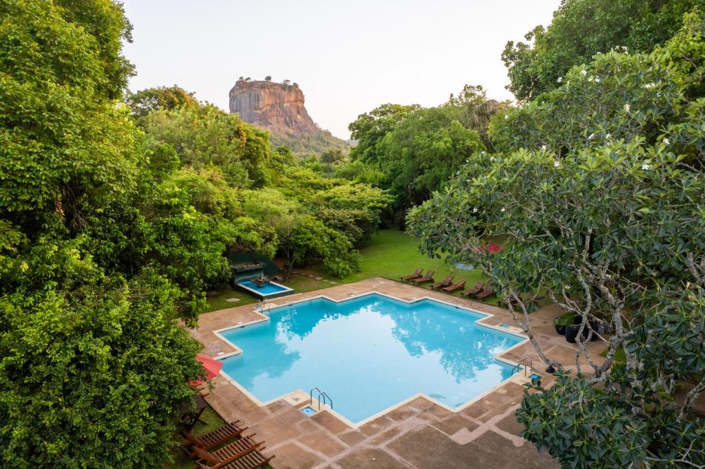 锡吉里亚科伦坡福特酒店的享有游泳池的顶部景色,背景为山脉