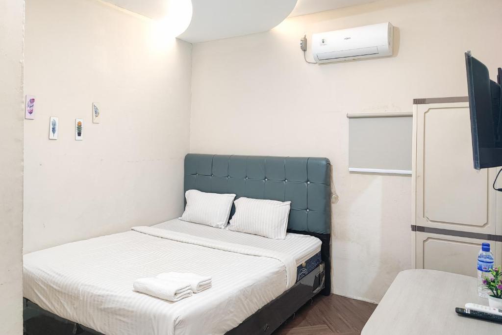PaalmerahRedDoorz Syariah near Transmart Jambi的小房间设有床铺和电视
