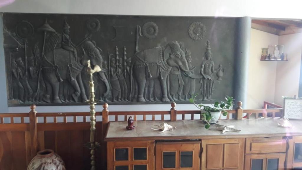 康提La Villa Lune Kandy的一间墙上挂有绘画的桌子的房间