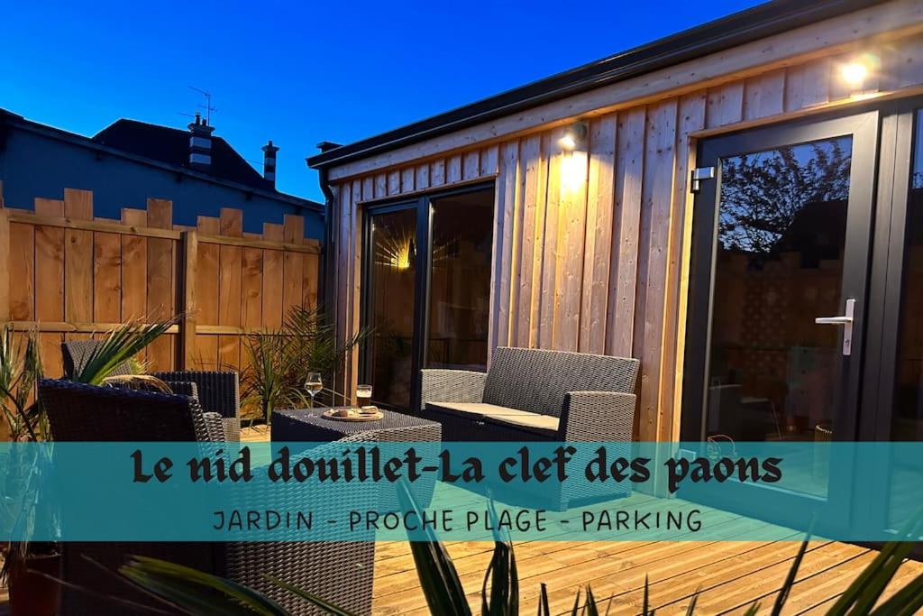 滨海吕克Le Nid douillet proche de la mer. La clef des paons的小型房屋设有带桌椅的庭院。