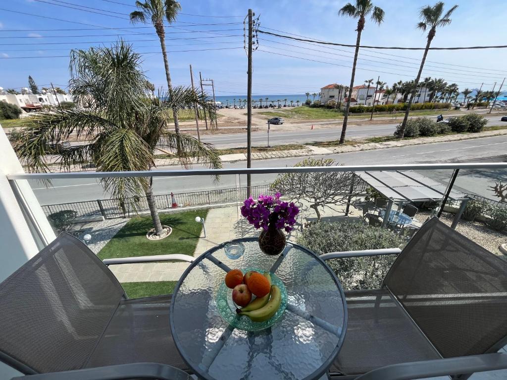 拉纳卡忒弥斯公寓的阳台上的玻璃桌,放着一碗水果和鲜花