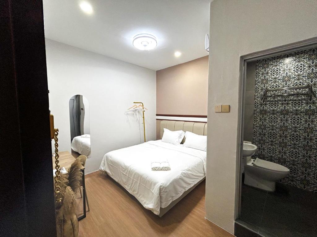 马六甲Mana Mana Hotel • Melaka •的一间小卧室,配有一张床和一个卫生间