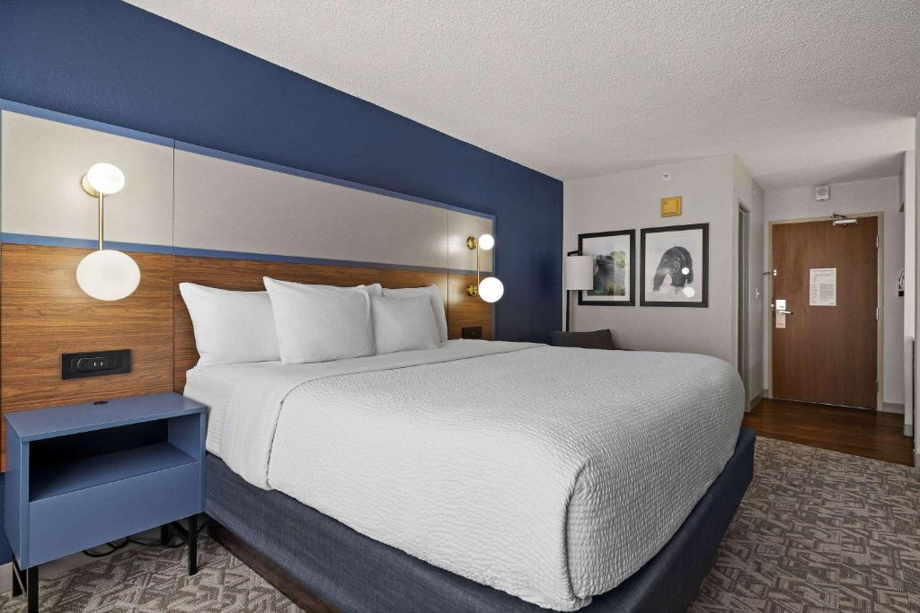 卡斯珀AmericInn by Wyndham Casper Event Center Area的一间卧室设有一张蓝色墙壁的大床