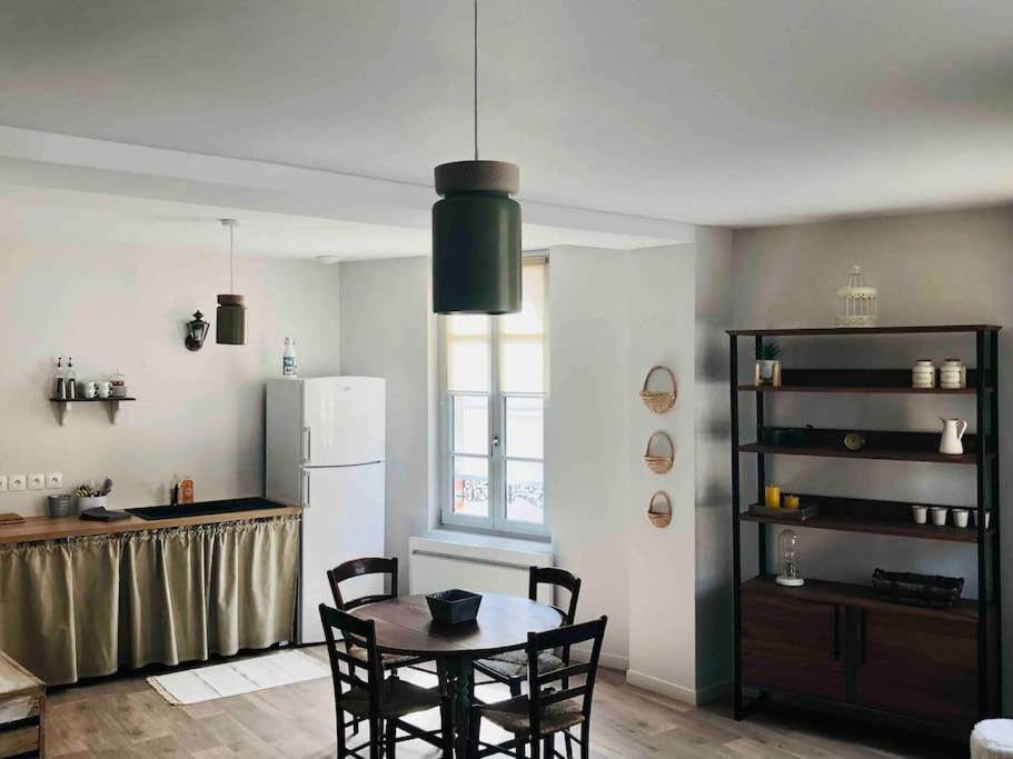 CormicyAppartement duplex cosy的厨房配有桌椅和冰箱。