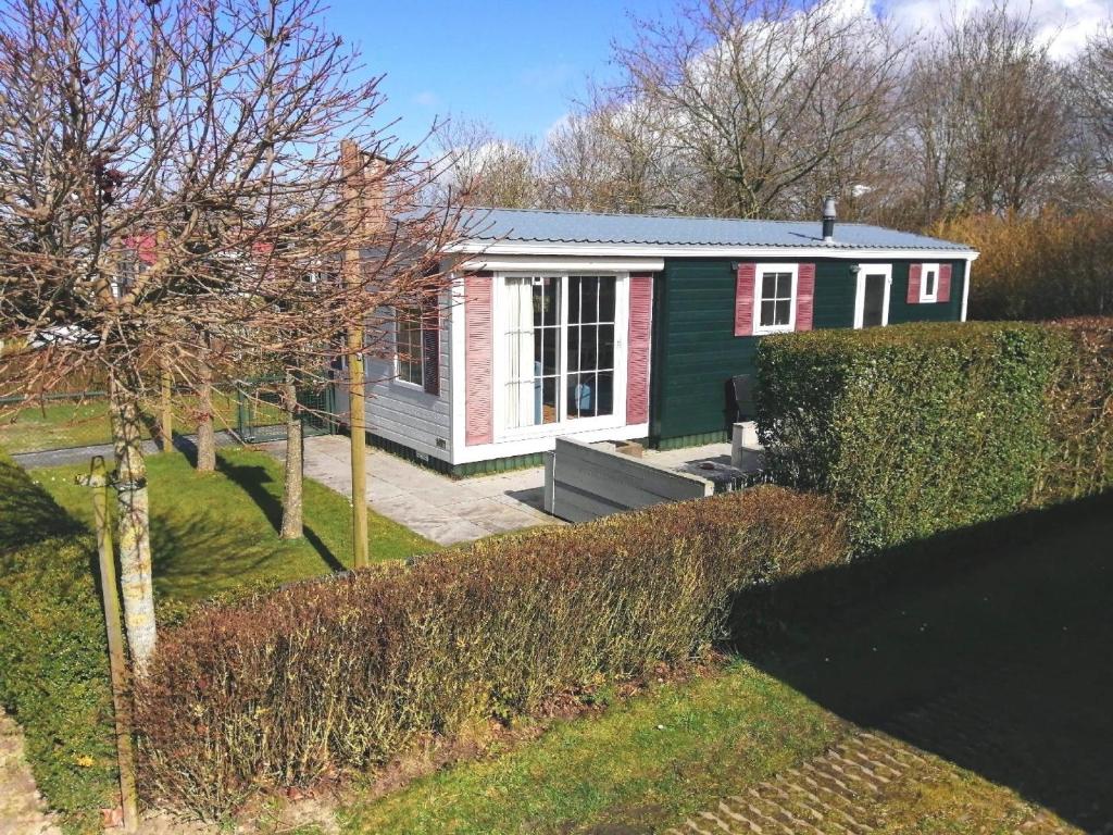 BaarlandFerienhaus für 6 Personen 1 Kind ca 41 qm in Baarland, Zeeland Küste von Zeeland的一座红色绿色的小房子