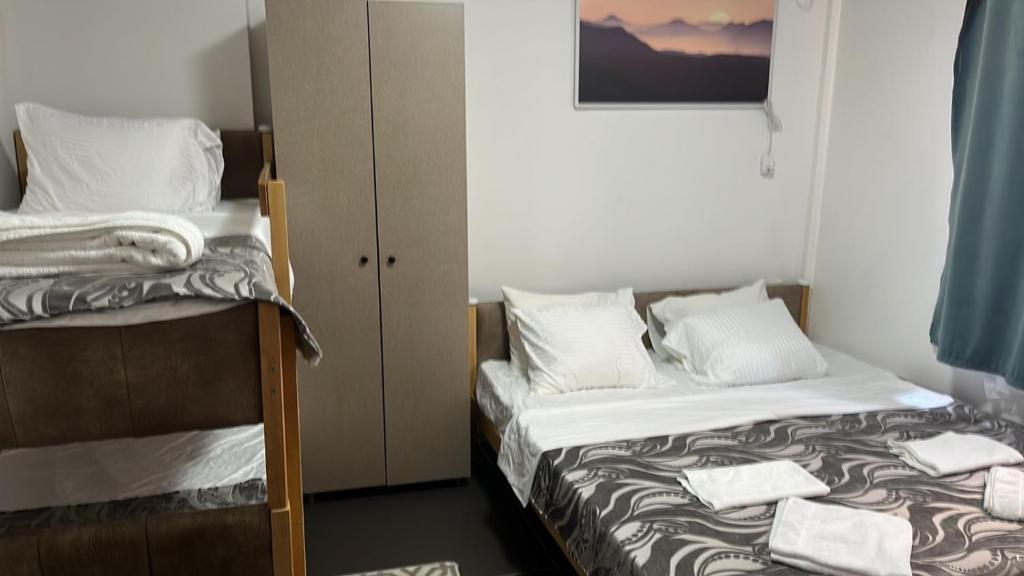 普里什蒂纳Hotel City Rooms Prishtina的一间卧室配有两张床和一张双层床。