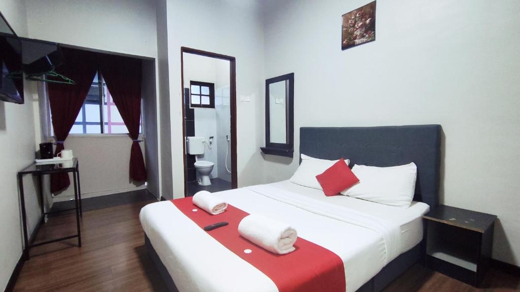 丹那拉打Hotel Rasa Sayang 2的卧室配有带红色枕头的大型白色床