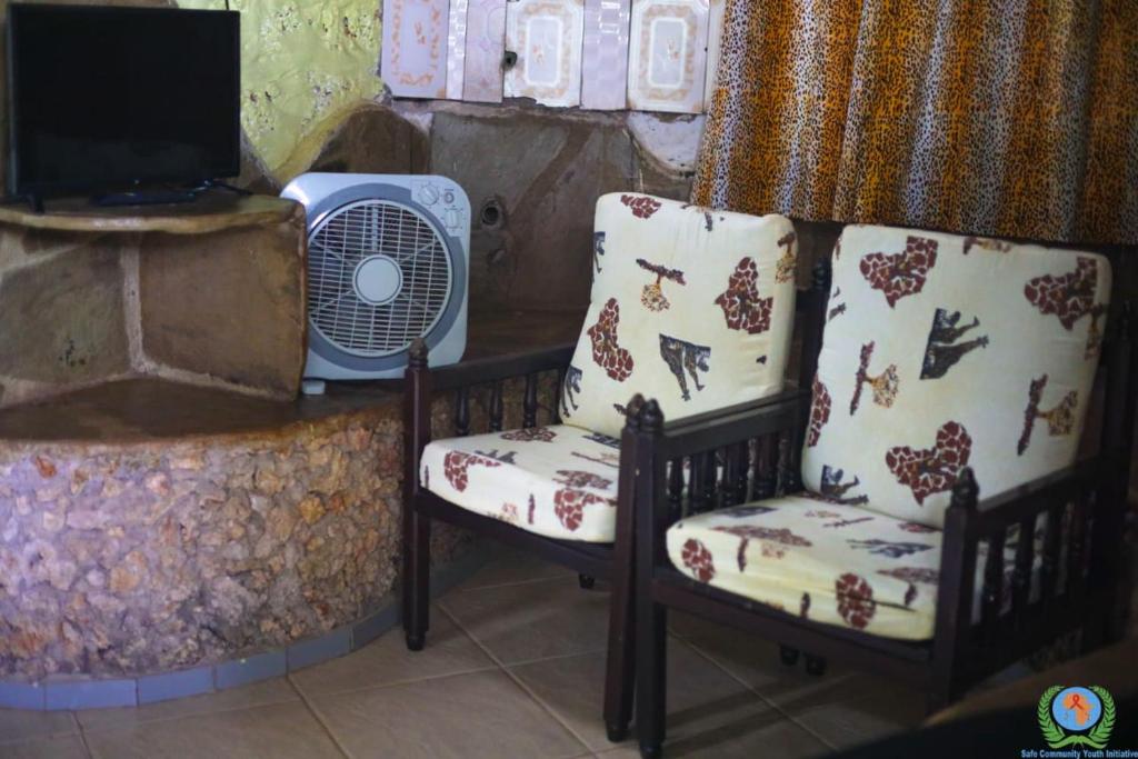 蒙巴萨Kikambala Eco Villas的暖气旁的两把椅子和风扇