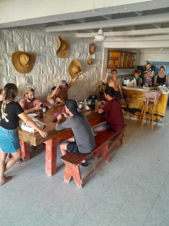 RincónTaida Hostel Rincon del Mar的一群坐在餐厅桌子上的人