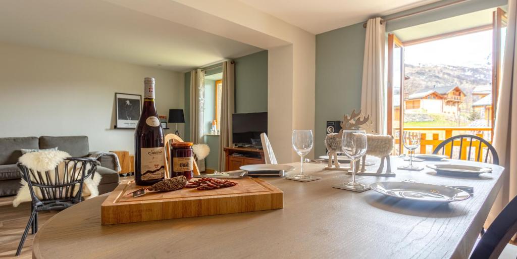 Saint-MarcelChalet Mariejo, Sauna et Charme Alpin的客厅的木桌旁的一瓶葡萄酒