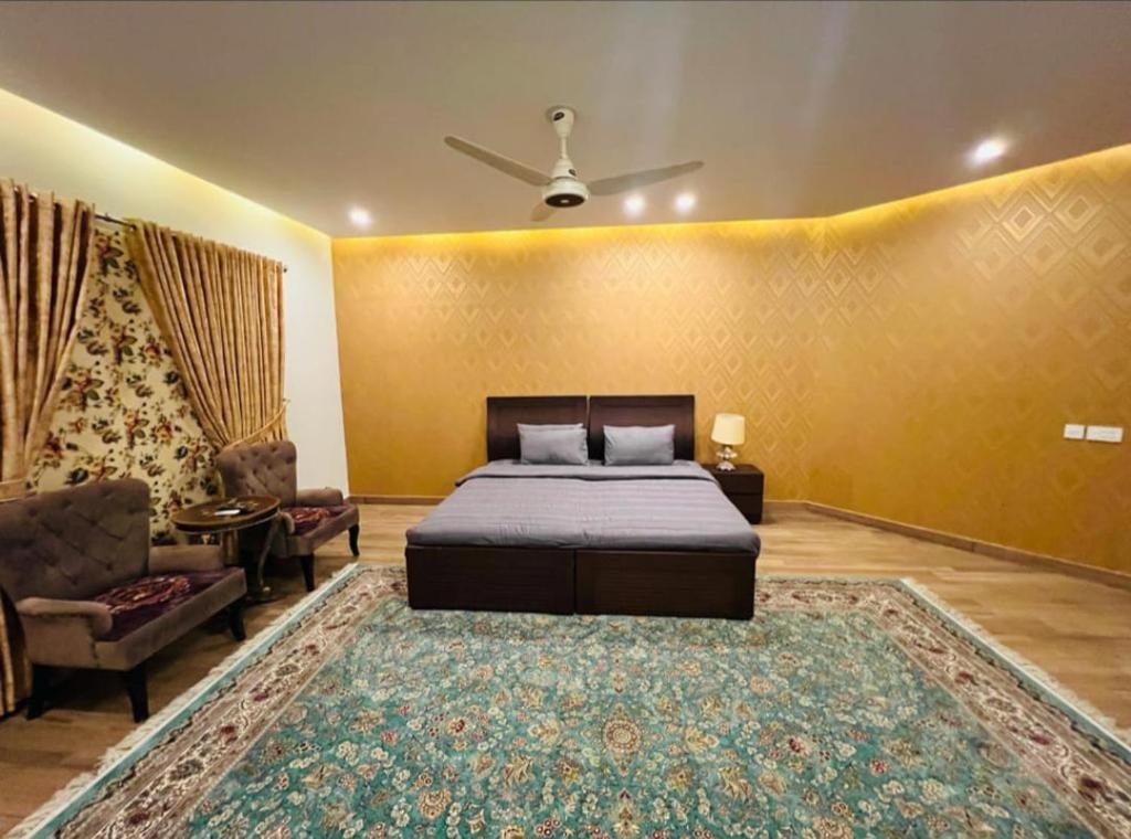 伊斯兰堡Pearl Executive Villa Islamabad的一间卧室配有床、沙发和地毯。