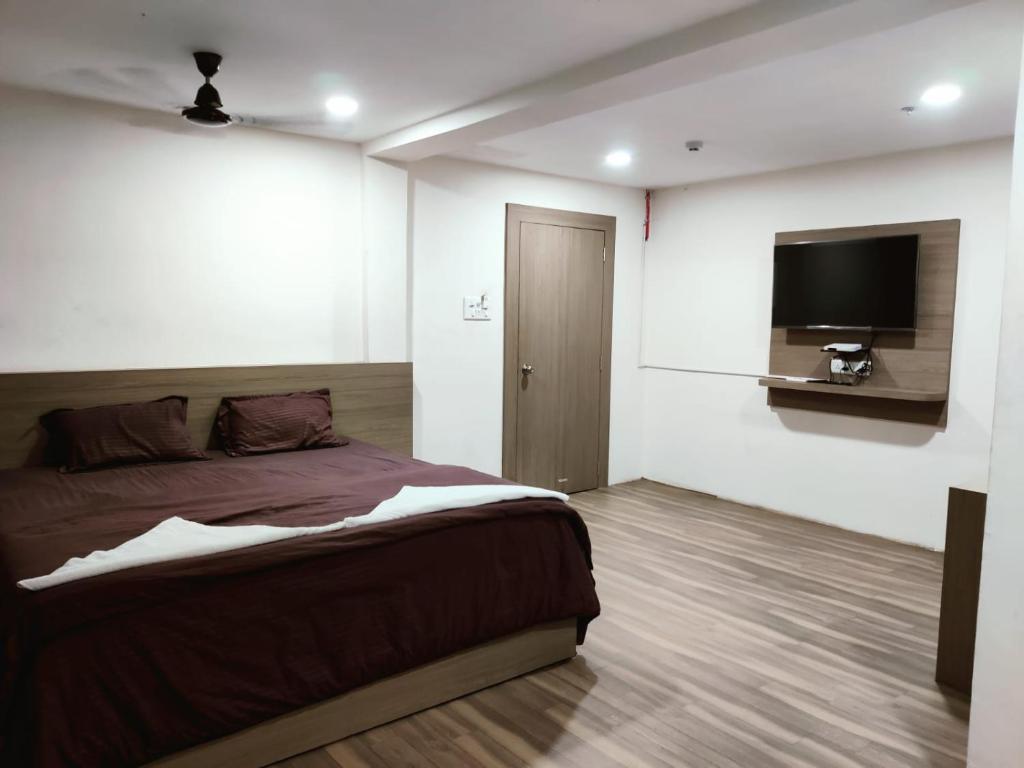 达曼HOTEL NEW RATNAKAR的一间卧室配有一张床和一台平面电视