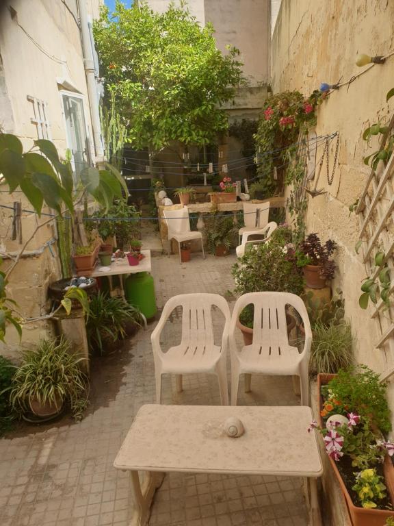 姆西达1, 2 or 3 Bed Rooms - Malta Central Location, Very near Sea and Tourism hub的庭院里设有两把白色的椅子和一张桌子