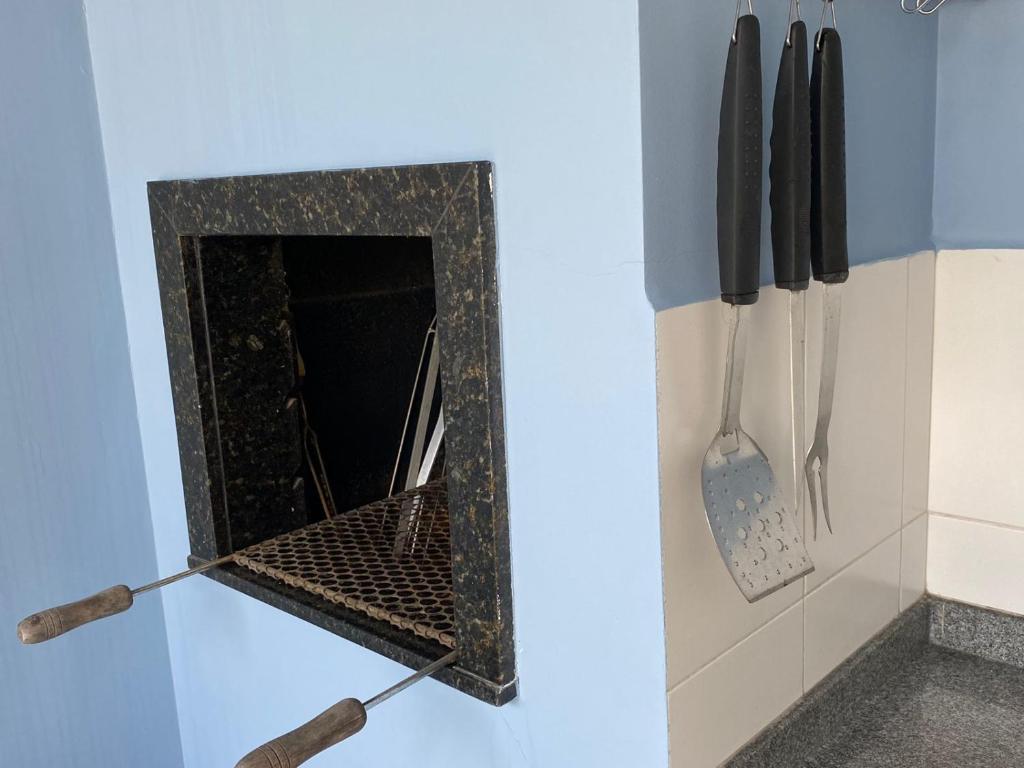 库里提巴Casa do Jardim的厨房配有带刀具和餐具的壁炉