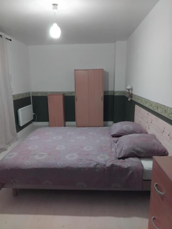 Saint-Cyr-des-GâtsDéconnection的一间卧室配有一张带紫色床单的大床