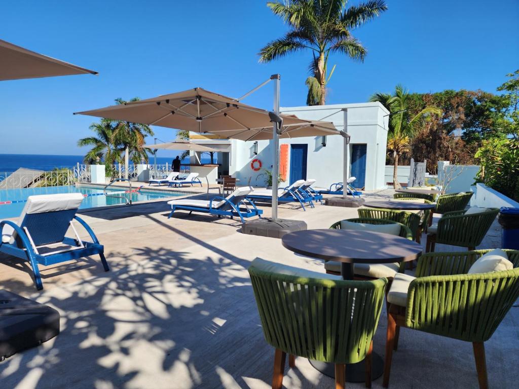 蒙特哥贝Hotel 39 Jamaica的庭院配有桌椅和遮阳伞。