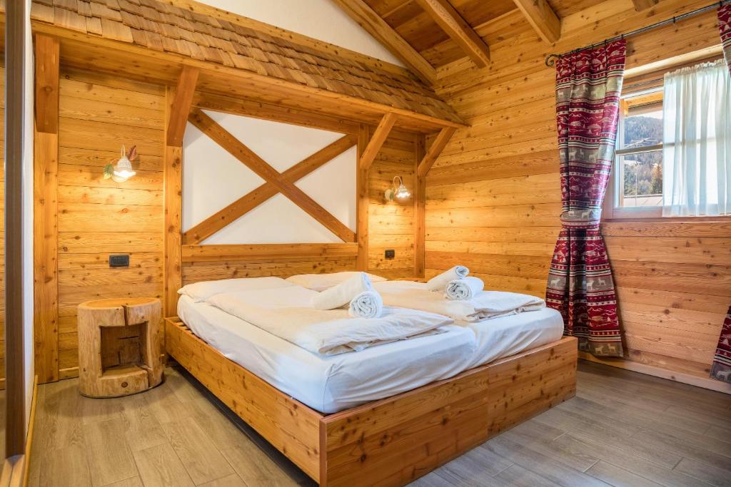 摩德纳迪-坎皮格里奥Chalet Camping Faè 1的小木屋内一间卧室,配有一张床