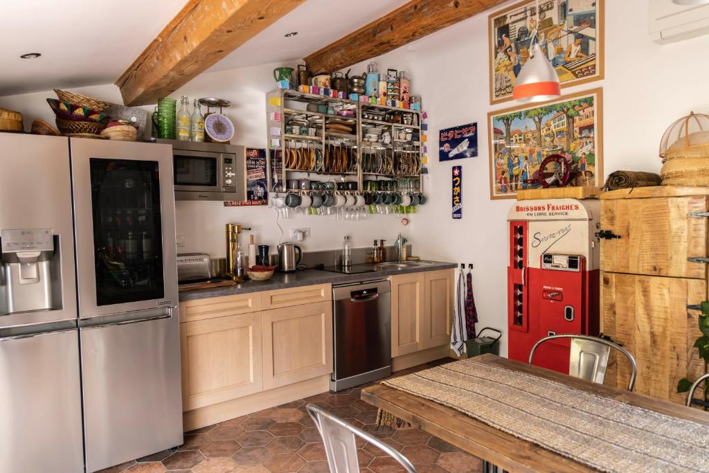 TautavelOrigines的厨房配有桌子和红色冰箱