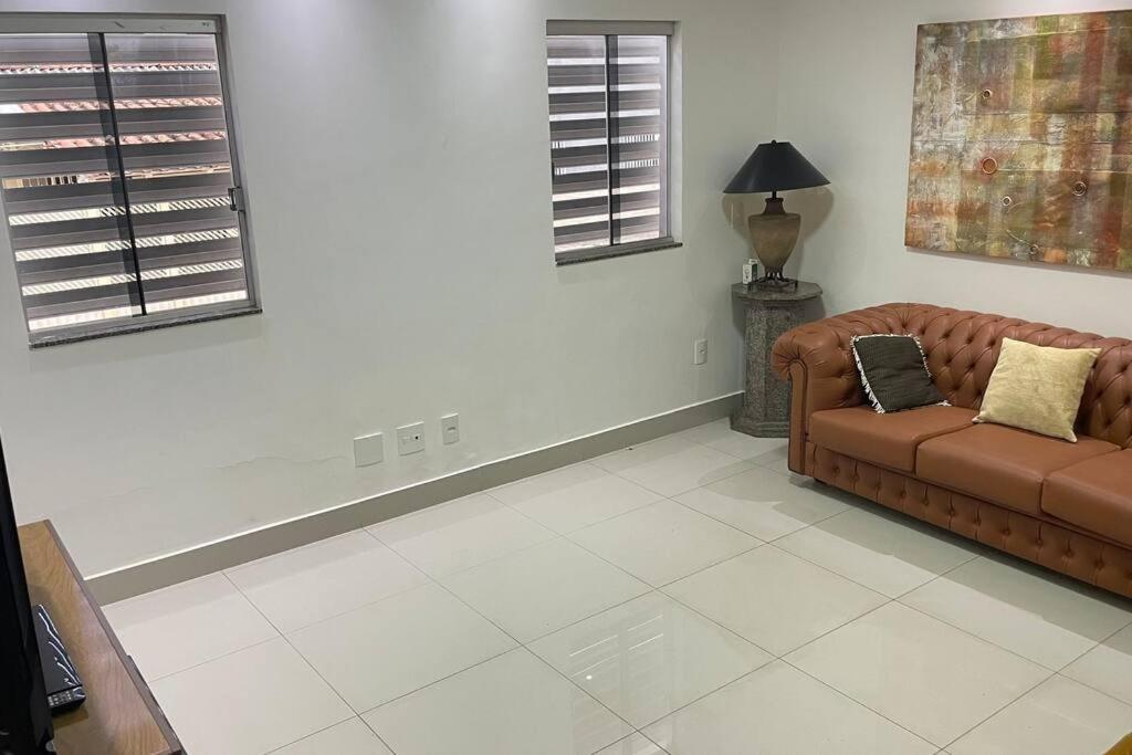 巴西利亚Casa próximo do aeroporto de Brasília的客厅设有棕色沙发和2扇窗户。