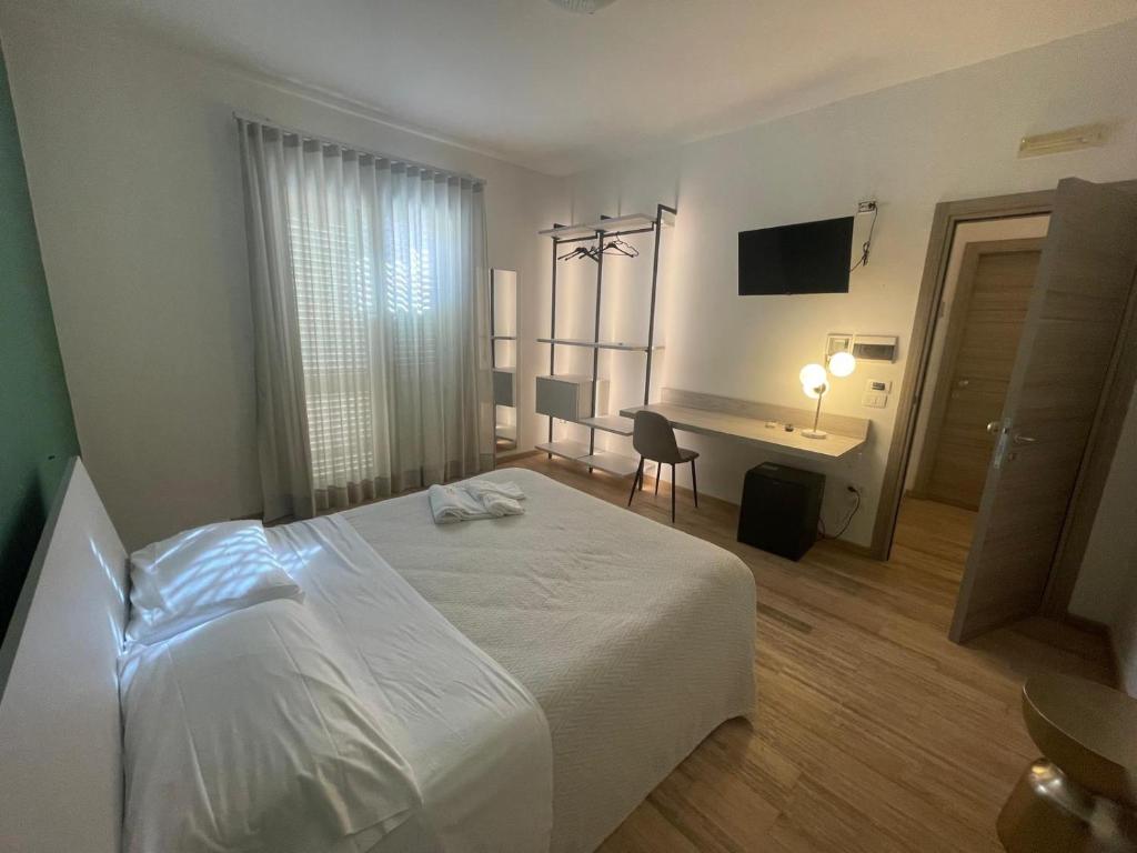 波托帕洛阿尔伯戈佩尔塞奥酒店的卧室配有白色的床和书桌