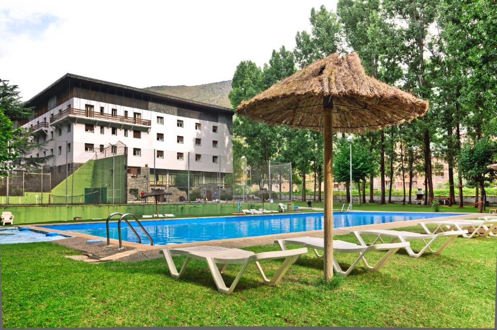 里亚尔普孔德斯德帕拉斯RV酒店的游泳池旁配有两把椅子和一把遮阳伞