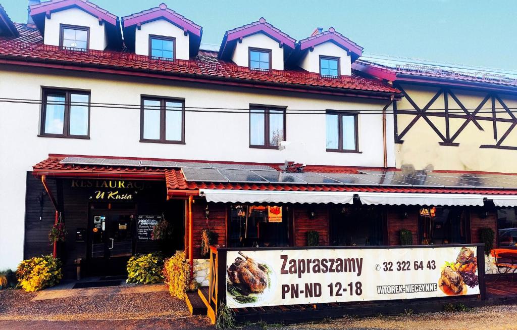 米科武夫Pokoje gościnne Restauracja u Kusia的前面有标志的建筑