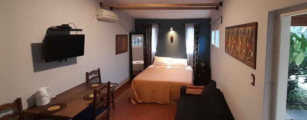 科尔多瓦Cerro de las Rosas的一间卧室配有一张床、一张桌子和一台电视。