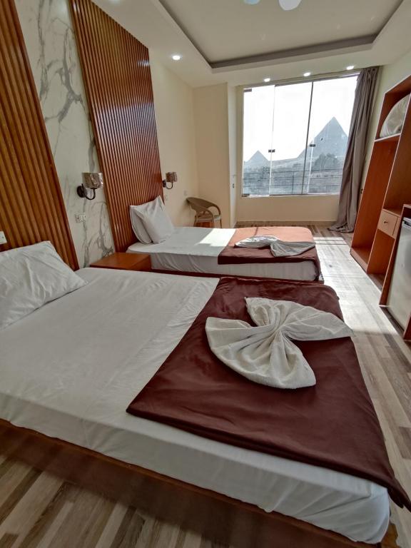 开罗dream pyramids view的两张位于酒店客房的床,配有毛巾
