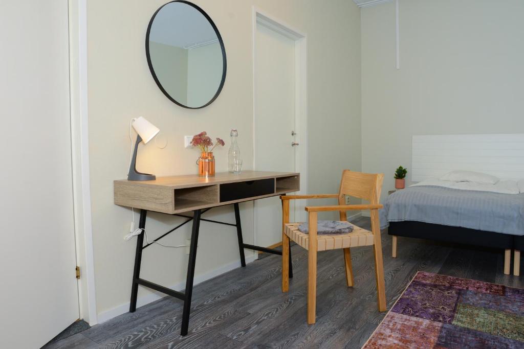 克里斯蒂娜港Britz Hostel的一间卧室配有书桌、镜子和床