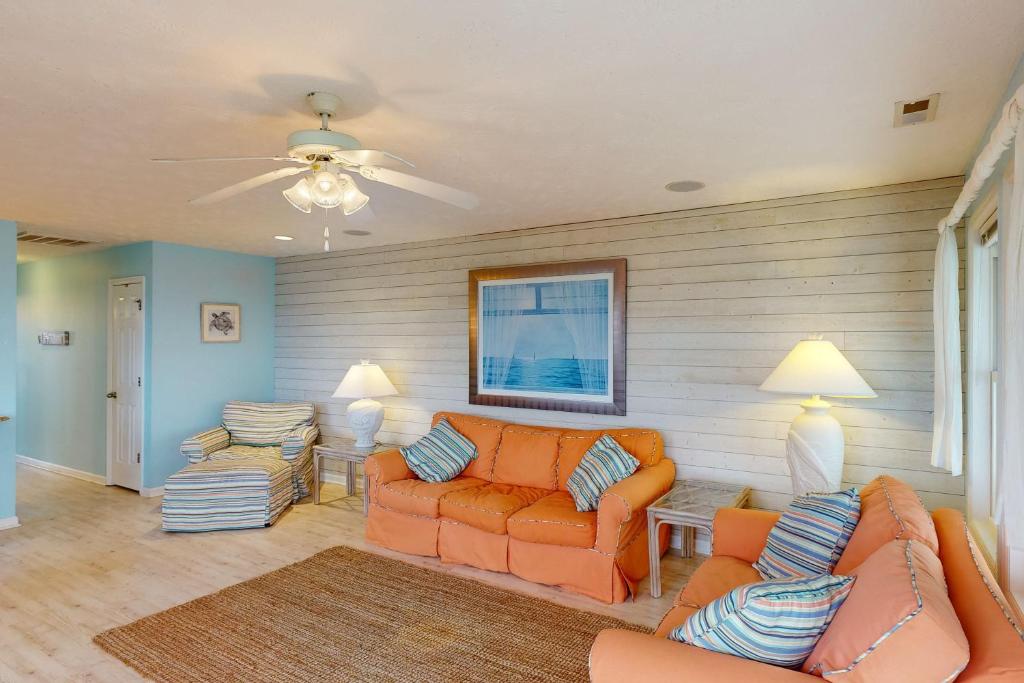 瑟夫城Home by the Sea的客厅配有橙色家具和吊扇