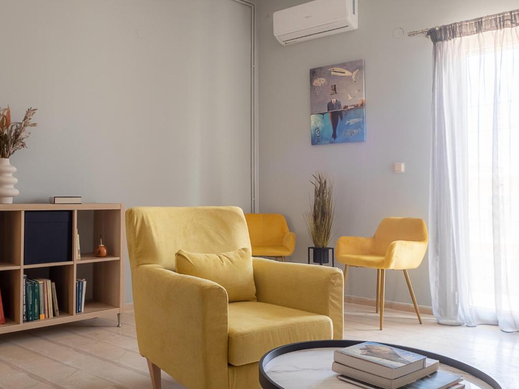 卡沃斯Andronikos Guest House的客厅配有黄色椅子和桌子