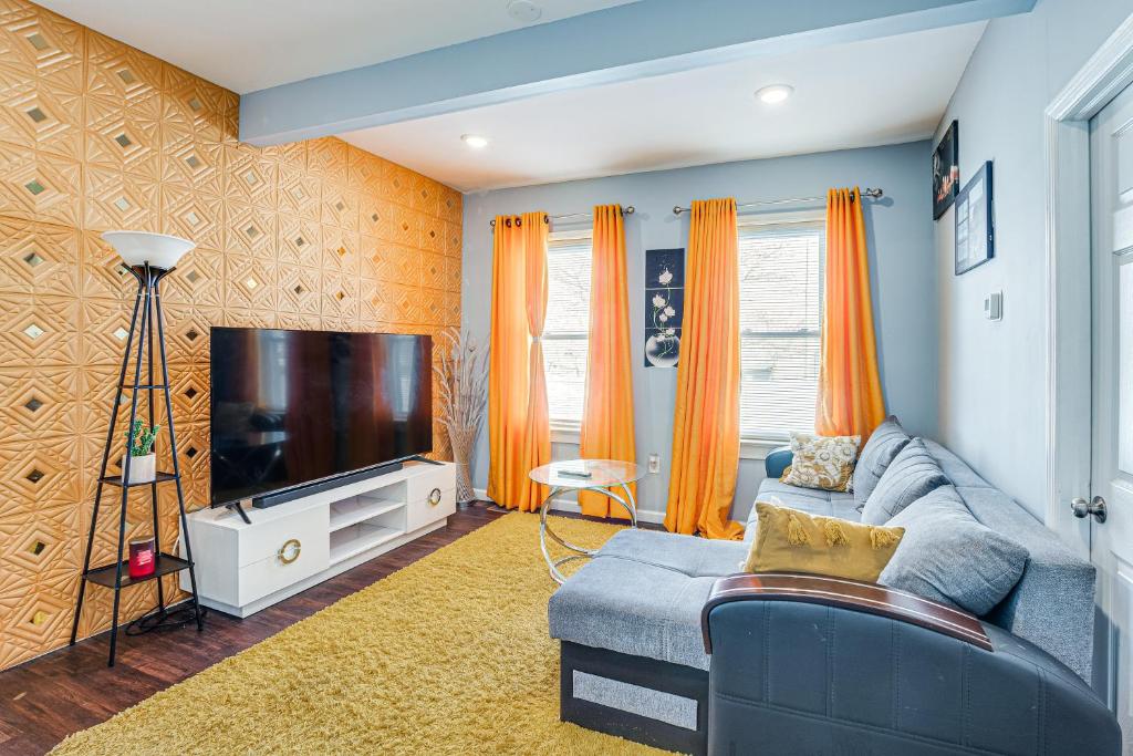 林登Updated Linden Home Visit NYC and Newark!的客厅配有蓝色的沙发和平面电视。