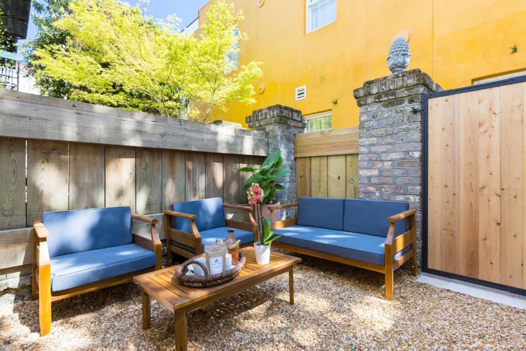 查尔斯顿State St A by AvantStay Heart of French Quarter的庭院配有3把蓝色椅子和桌子