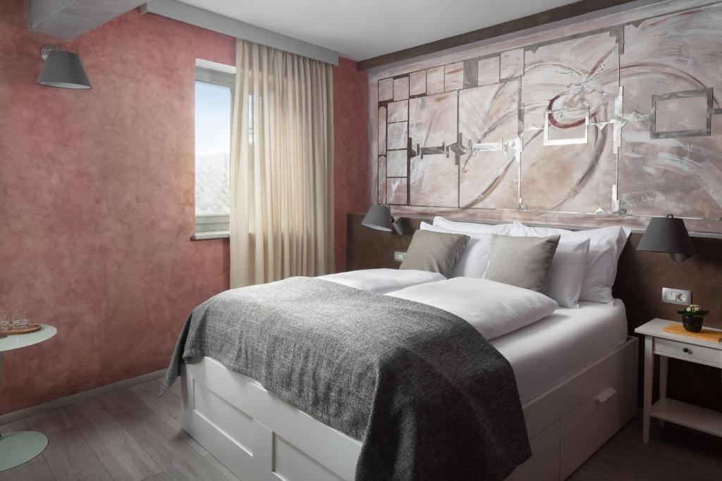 拉宾Mirakul Residence的卧室配有一张大床,墙上挂有绘画作品