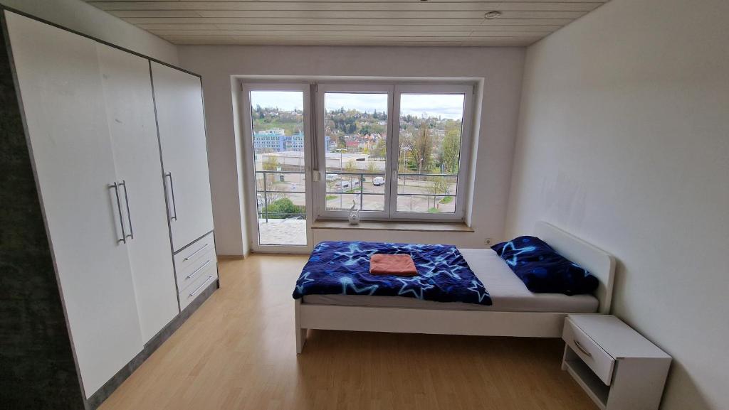 施瓦格明德Rooms & Apartments Schwäbisch Gmünd的一间卧室设有一张床和一个大窗户