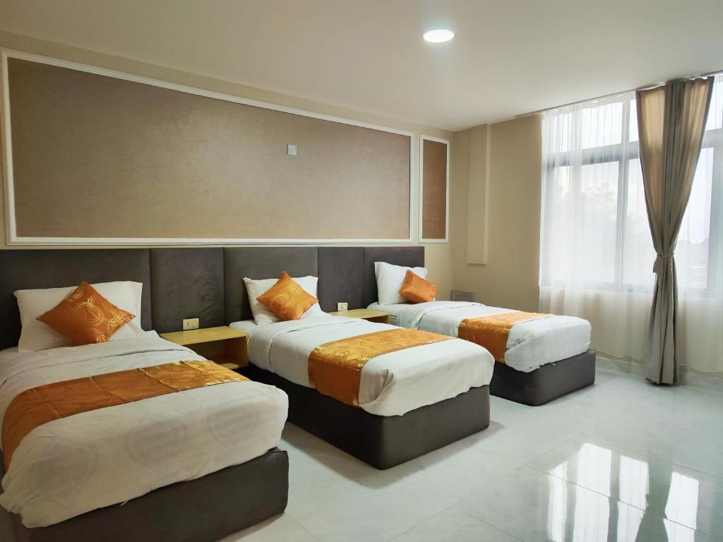 瓦迪穆萨Rakan ApartHotel and Luxury Rooms的酒店客房设有两张床和窗户。
