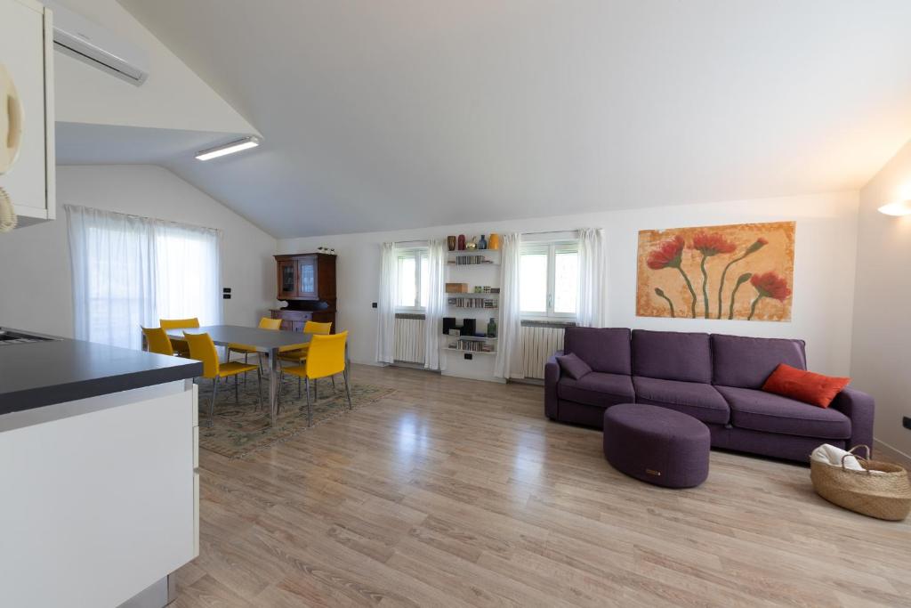 阿萨哥Casa Vecchia Quercia的客厅配有紫色沙发和桌子