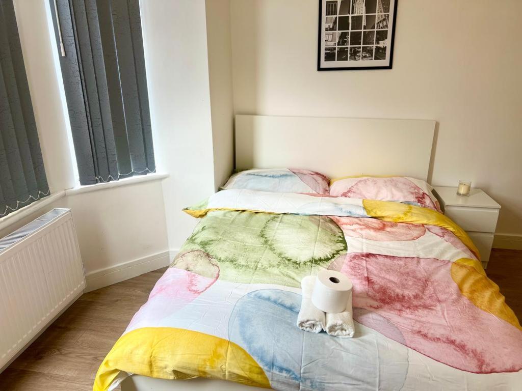 曼彻斯特En-suit double bedroom with bathroom in Manchester的一间卧室配有一张带彩色毯子的床