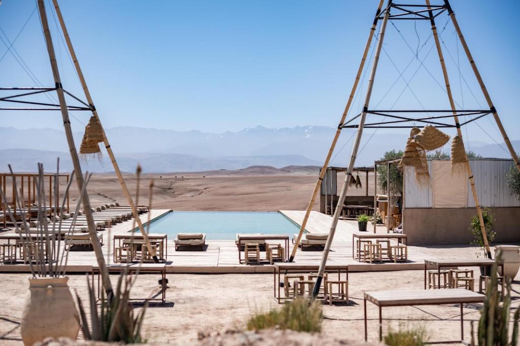El KariaLes Terrasses d'Agafay的沙漠中的一组椅子和一个游泳池