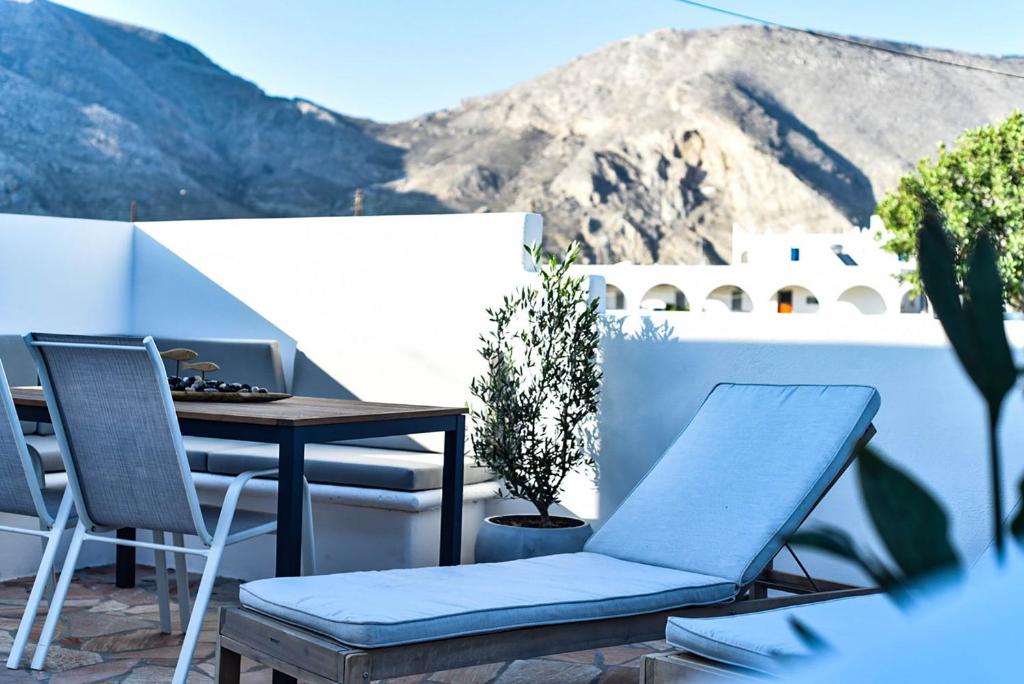 佩里萨DP Homes Santorini的阳台配有桌椅,享有山景。