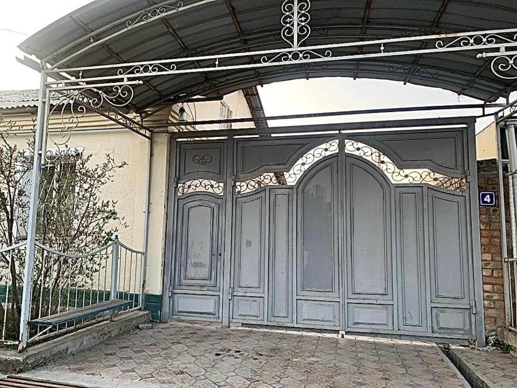 奥什Altan Hostel Osh的一个大入口,有大灰色的门