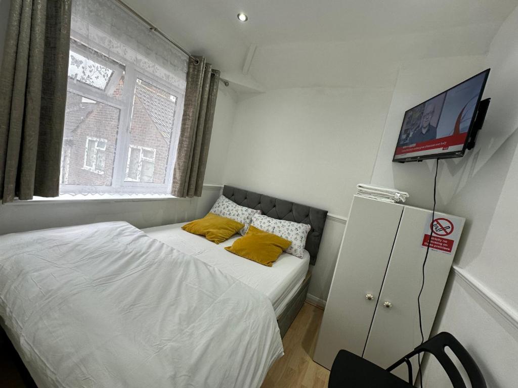 布罗姆利Cosy Smart/Small Double Room in Keedonwood Road Bromley的一间小卧室,配有一张床和一台墙上的电视