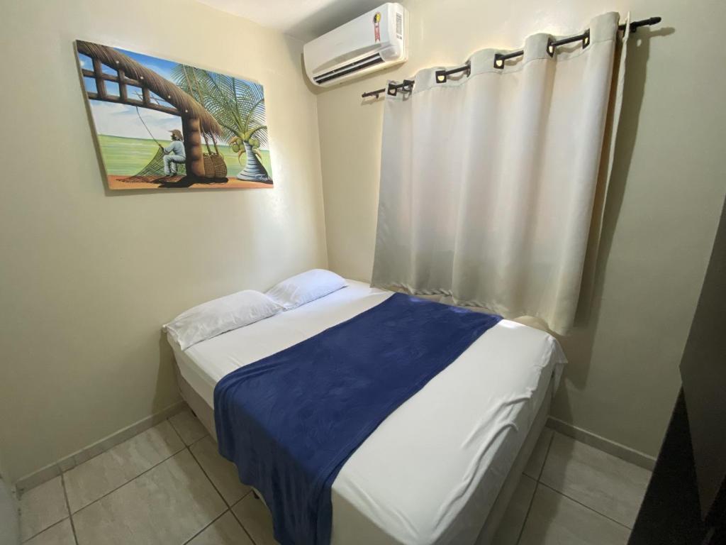 若昂佩索阿Hotel Pousada dos Anjos的小卧室配有一张带蓝色毯子的床