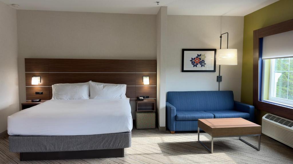 滨海城马里那智选假日套房酒店的酒店客房,配有床和蓝色的沙发