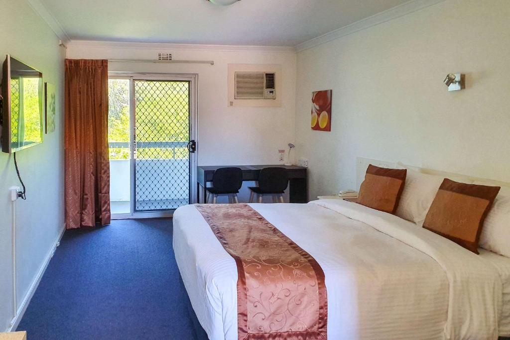 珀斯Econo Lodge Rivervale的酒店客房设有一张大床和一个阳台。