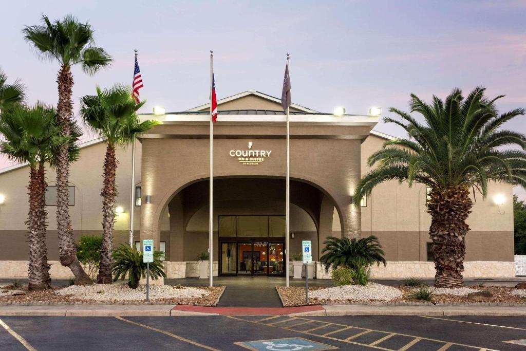 圣安东尼奥卡尔森拉克兰空军基地乡村套房酒店的停车场内棕榈树的购物中心