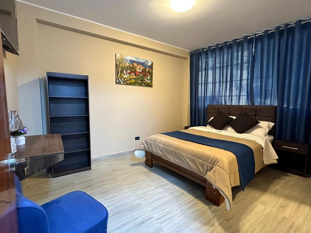 YungayGran Hotel的一间卧室配有一张床和一张蓝色椅子