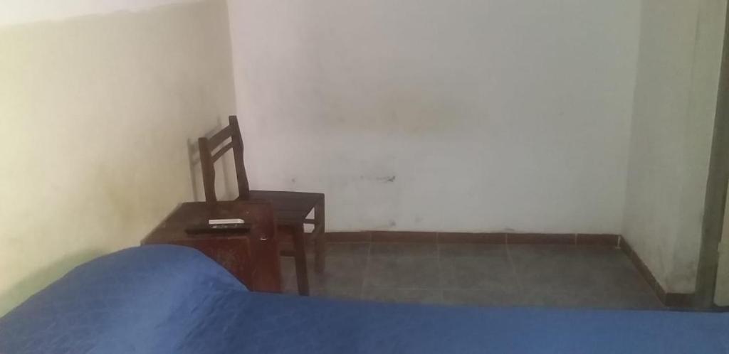 拉里奥哈Alojamiento en La Rioja + SERVICIO TURISTICO的一间卧室配有一张床、一张桌子和一把椅子