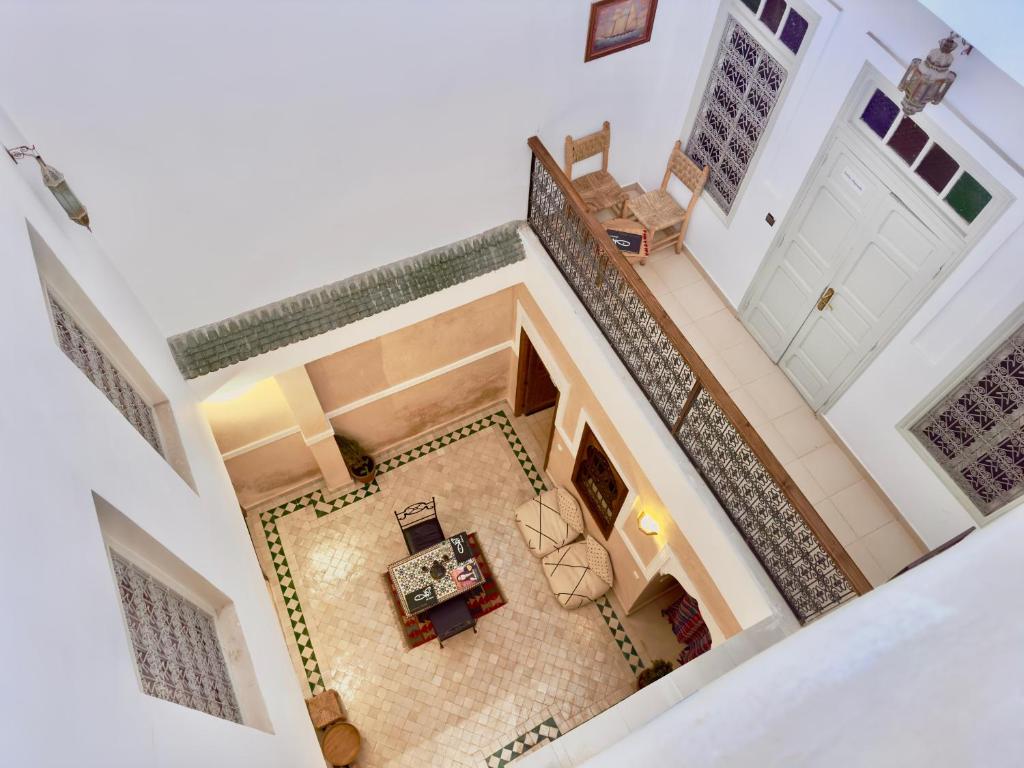 马拉喀什Riad Des Sables的客厅的顶部景色,客厅设有楼梯,位于房子内